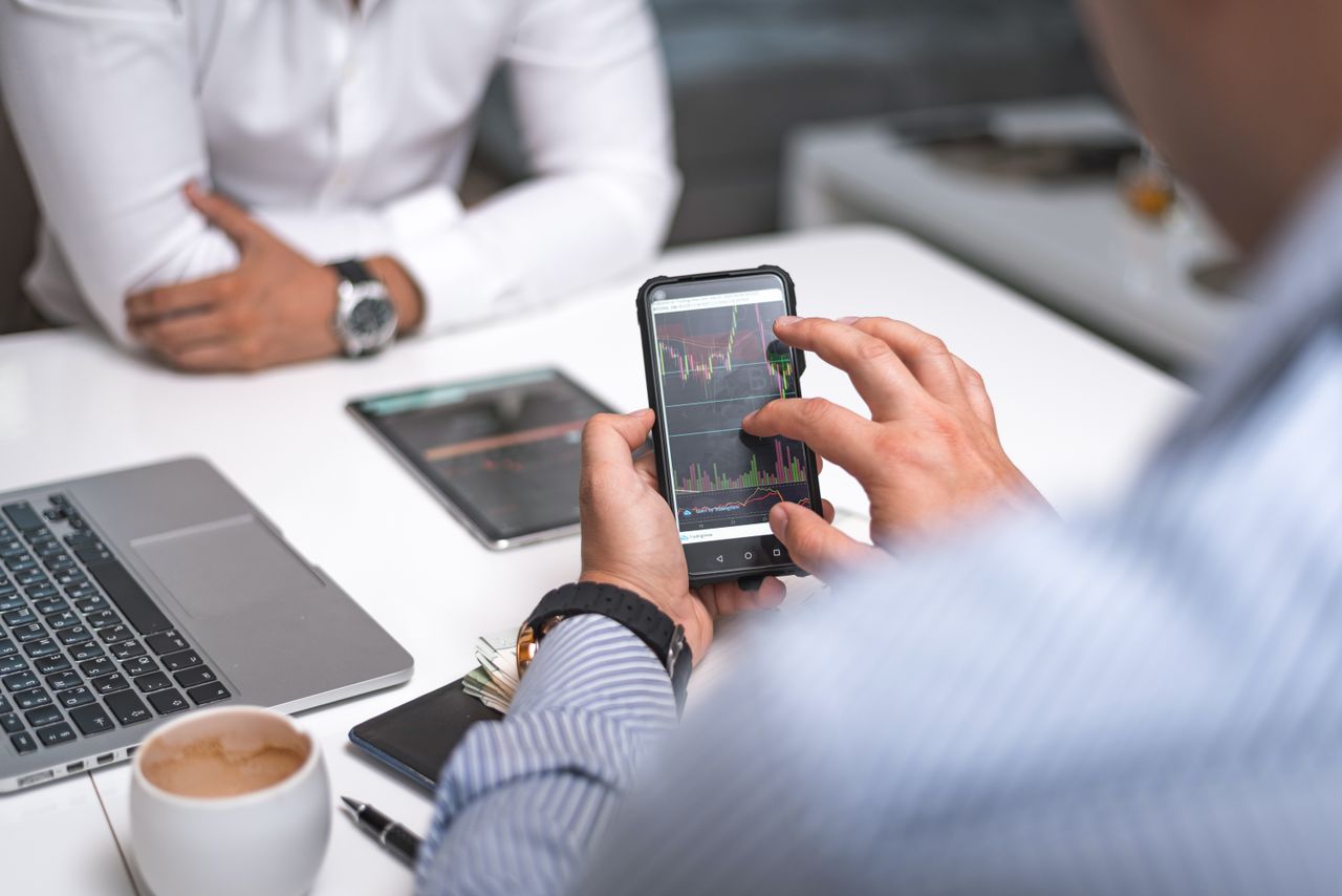 Business professionals using smartphone for data analysis in a modern office setting.